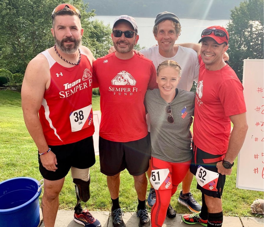 Brent Saunders standing outside with four people at a race